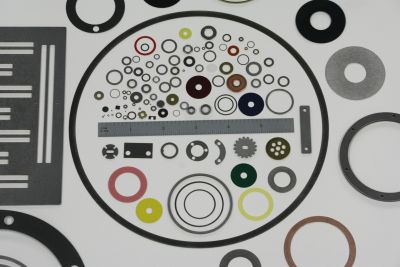 Comprehensive display of flat washers in multiple materials, colors, and sizes arranged on white background.