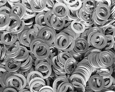 Pile of metal flat washers showing various sizes and thicknesses used in fastener applications.