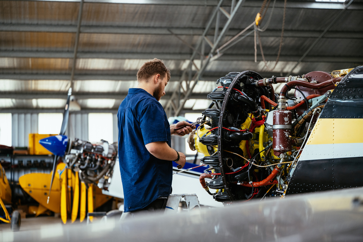 Technician servicing an aircraft engine, tightening an aerospace fastener.